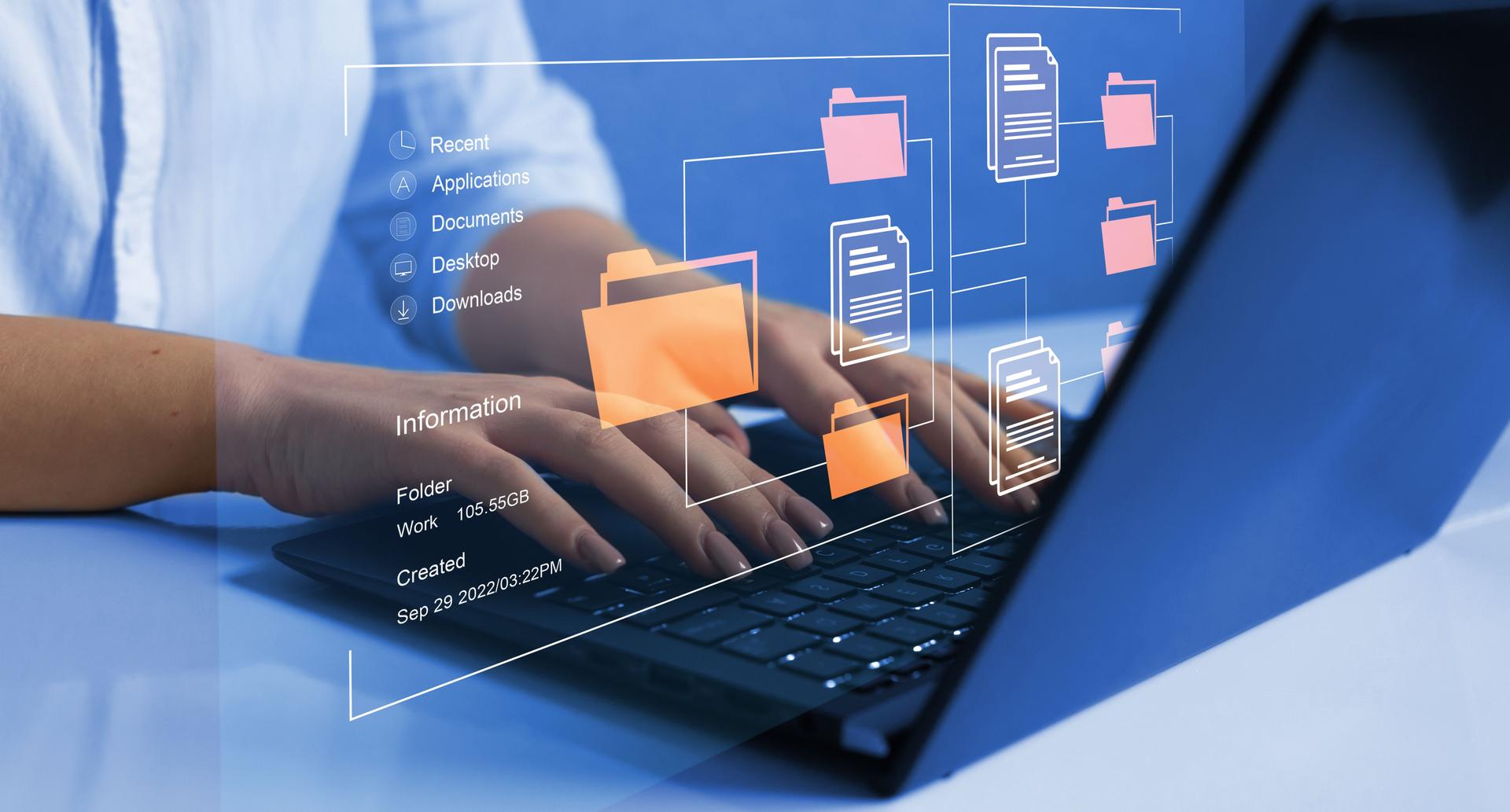 Person organizing digital files on a laptop, representing royalty accounting and data room preparation.